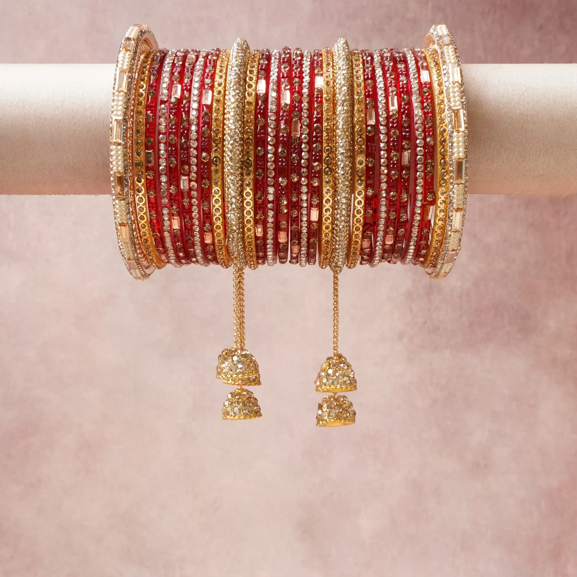 A grounding Crimson Red forms the heart of the set, while touches of Clear Crystal, Champagne Crystal, Cream Pearl add charm.

A thoughtful composition of Glass (for red bangles), Gold-plated Brass (for gold bangles, chains, and bells), Cubic Zirconia (for clear and champagne crystals), Imitation Pearl (for cream beads), designed to feel complete without being heavy.
Each element layers seamlessly, creating a look that is refined, wearable and quietly striking.
